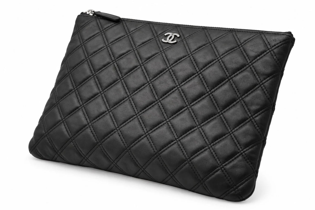 CHANEL black quilted caviar leather O-Case clutch angled front | Shop Authentique Lux
