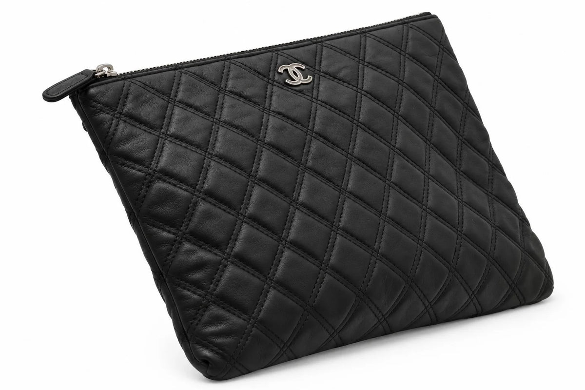 CHANEL black quilted caviar leather O-Case clutch side angle | Shop Authentique Lux