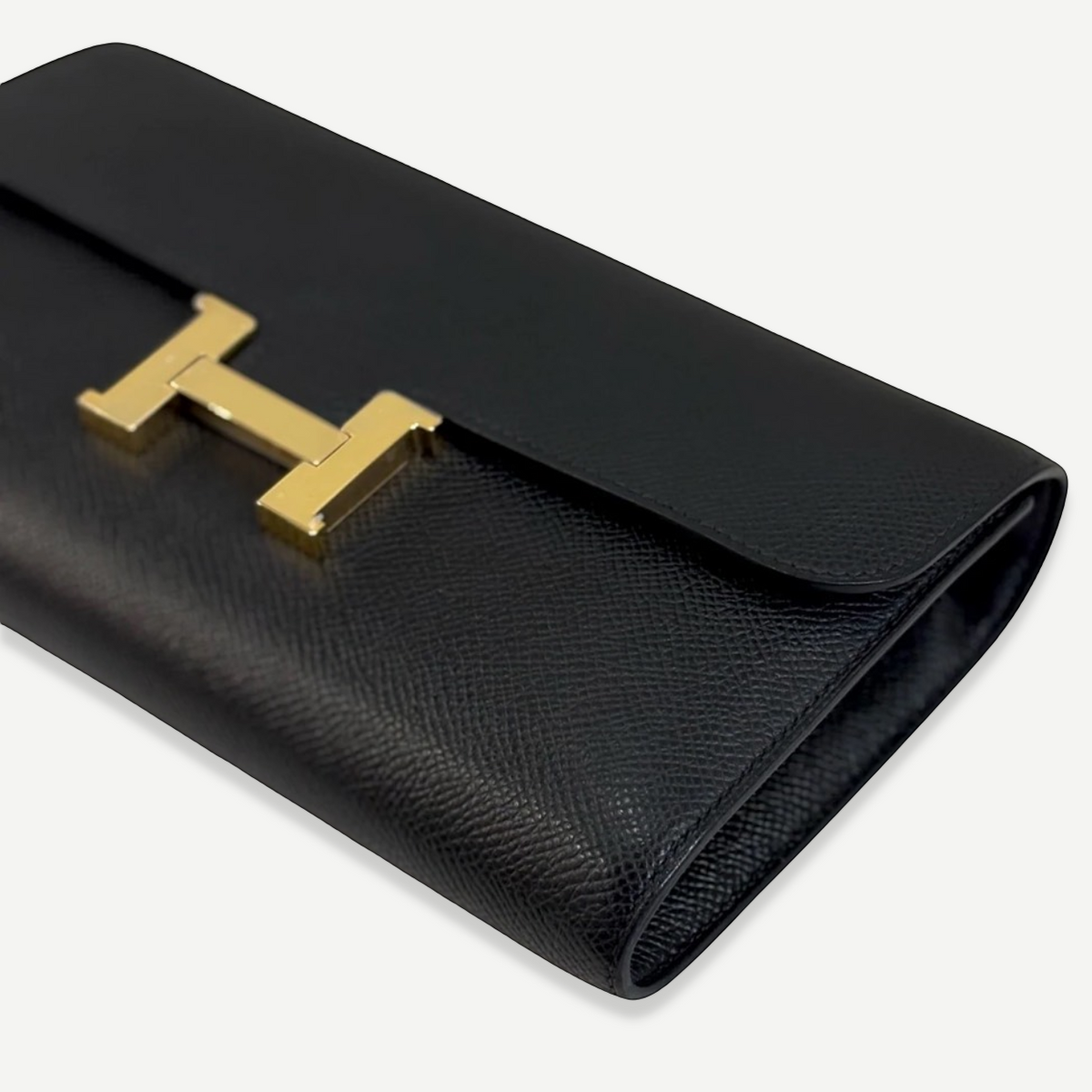 HERMÈS Noir Constance To Go, angled front view with gold H clasp | Shop Authentique Lux
